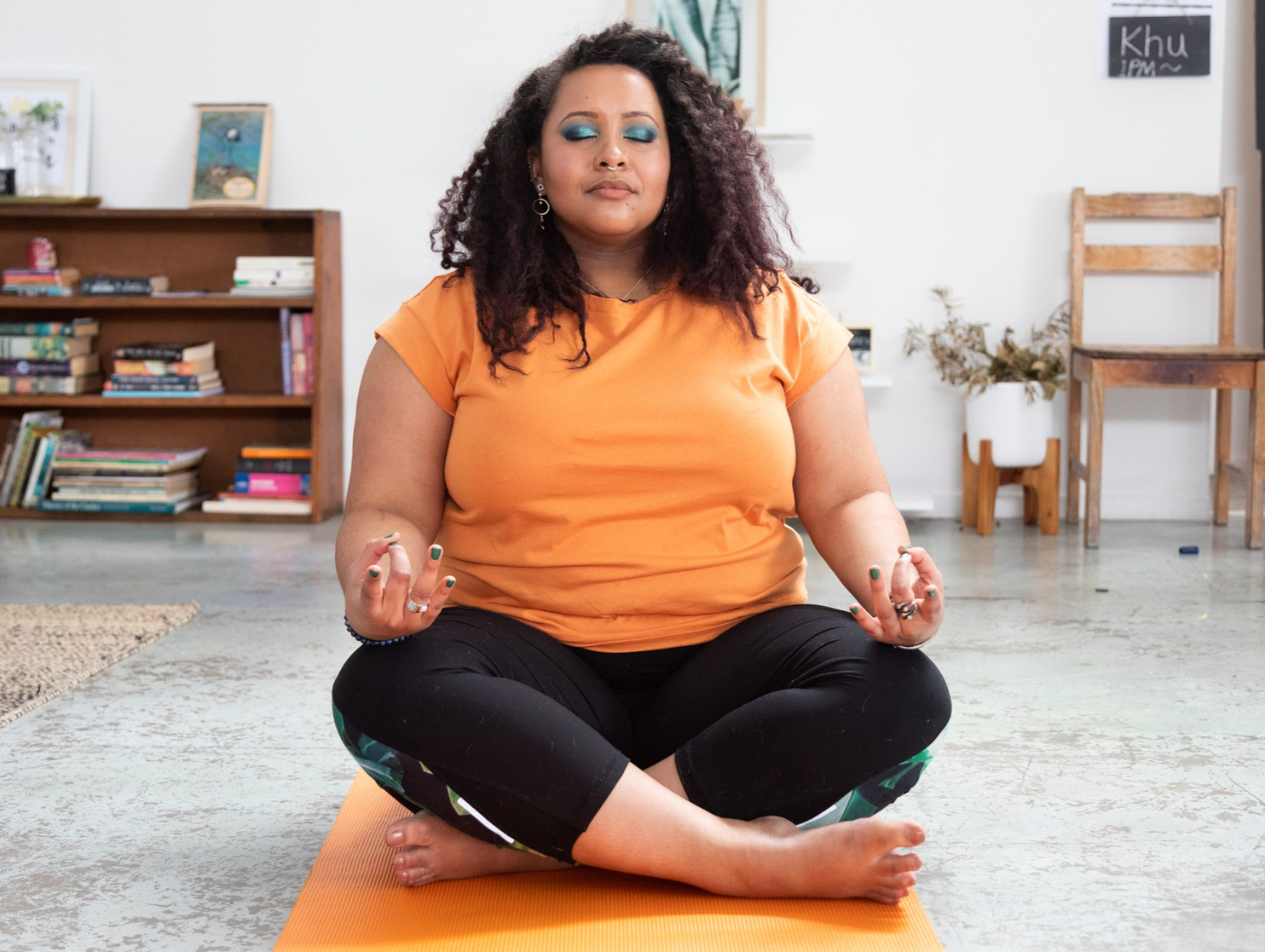Woman sitting cross legged on a yoga mat